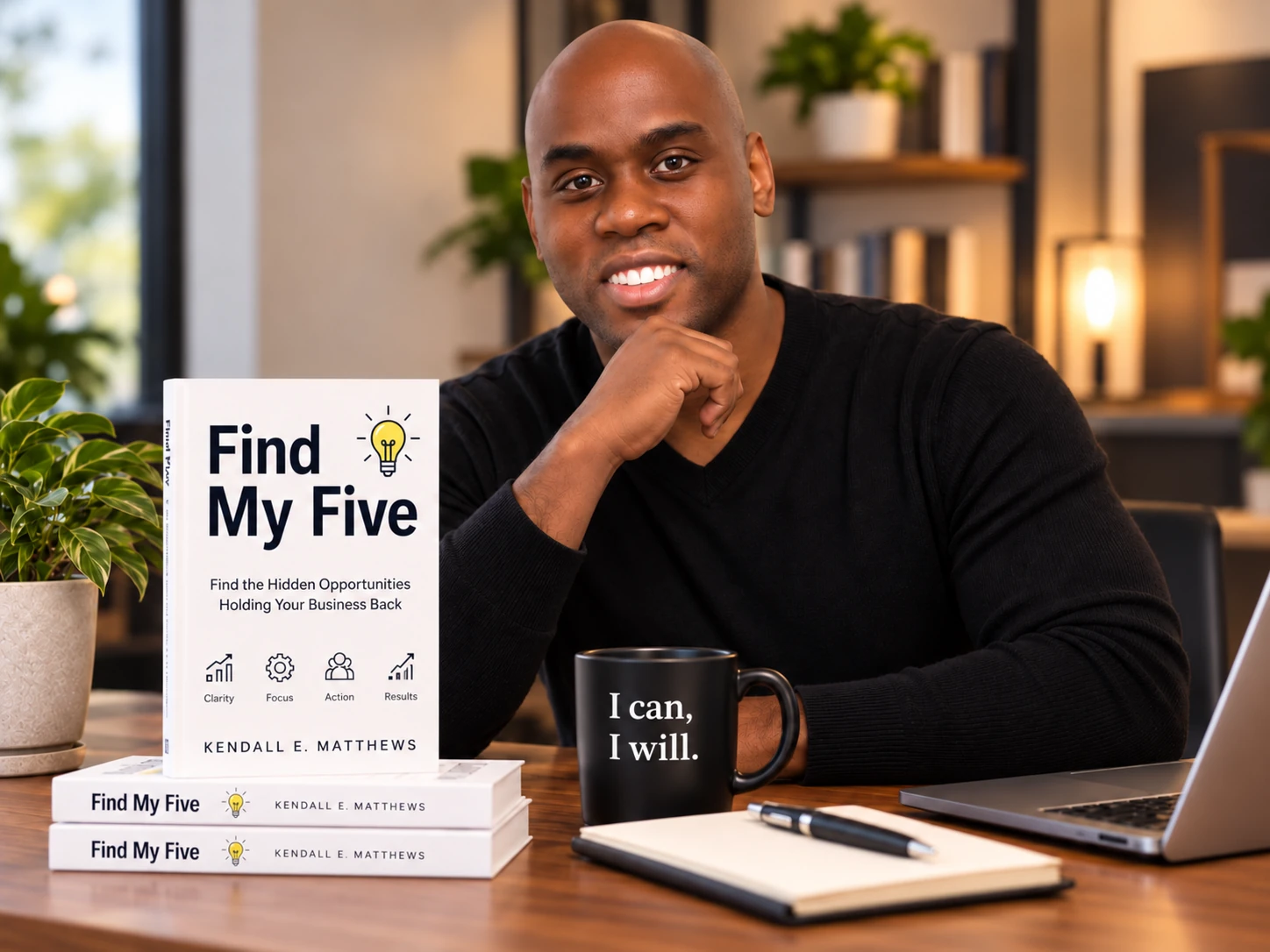 Kendall Matthews with the Find My Five business review booklet at his desk.